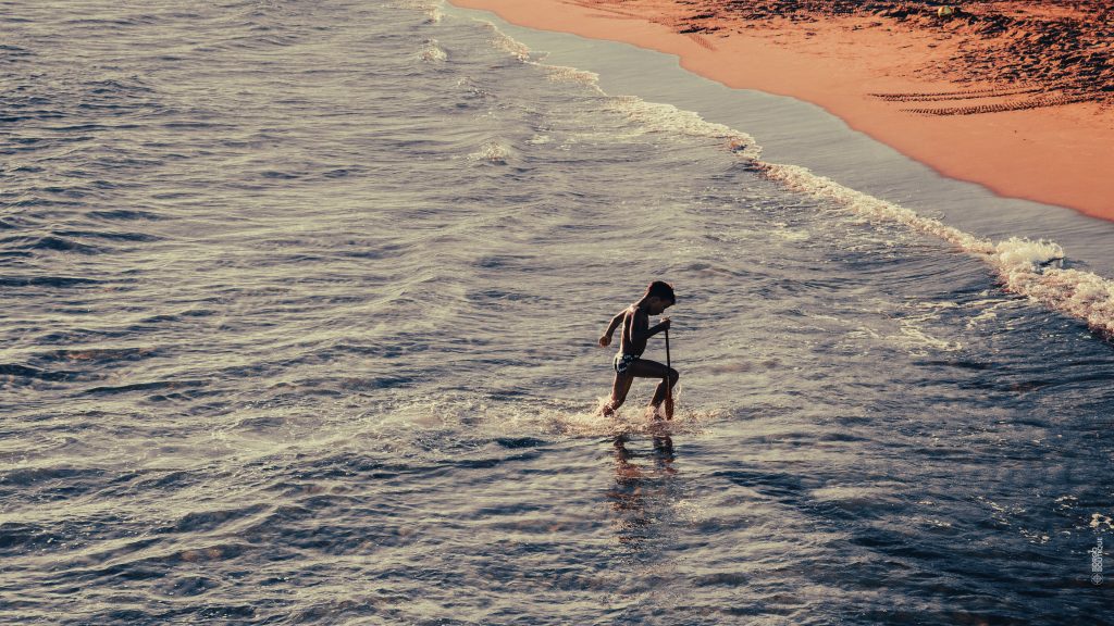 Boy running in water at the beach